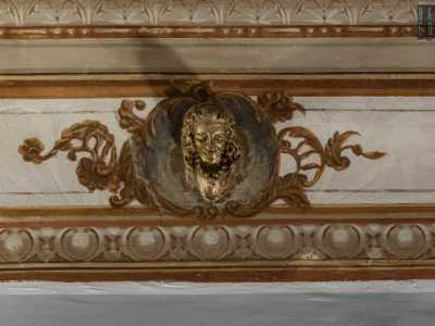 Arricchiscono la raffinata decorazione delle bronzee teste femminili con fastose collane che corrono lungo il perimetro della stanza